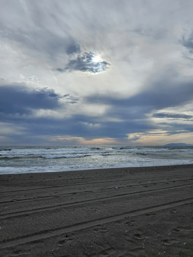 Plage calme sous un ciel d'hiver nuageux