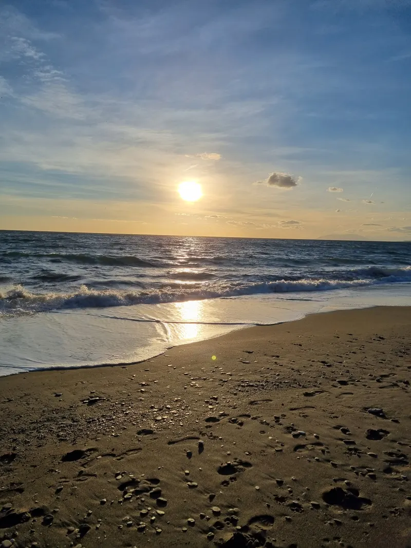 Goldener Sonnenuntergang spiegelt sich in den Wellen am Strand von El Morche