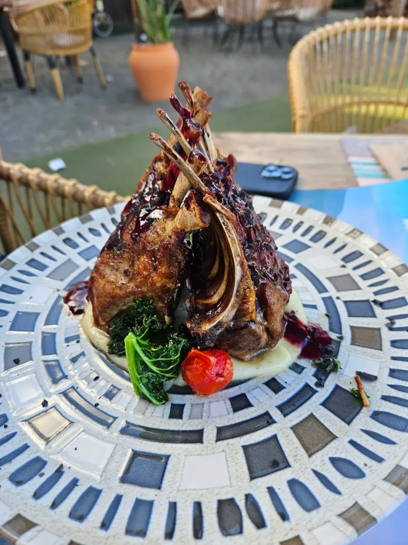Côtelettes d’agneau et légumes dans une assiette de restaurant à Torre del Mar